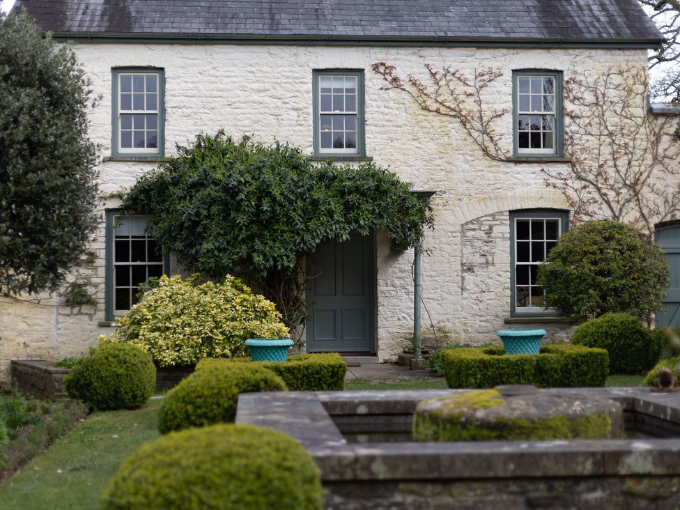 An exterior view of a house with plants in the garden at North Cottage in Myddfai near Llandovery