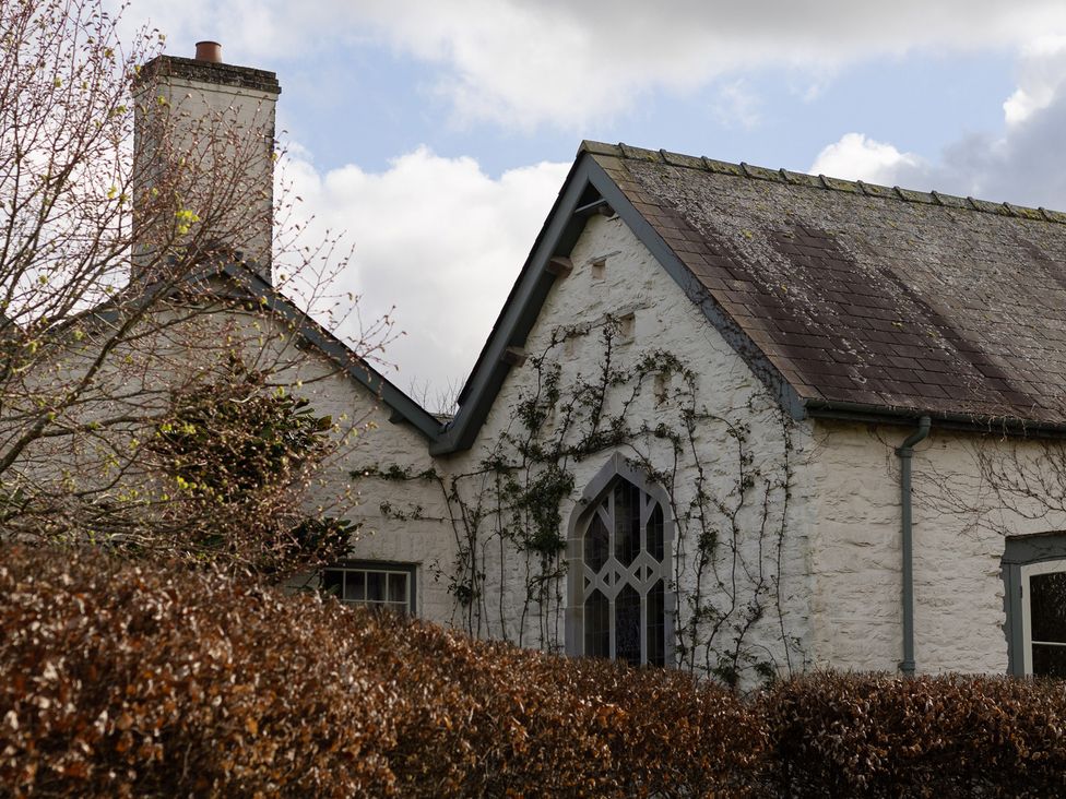 Exterior view of a house with a chimney and decorative window at North Cottage in Myddfai near Llandovery