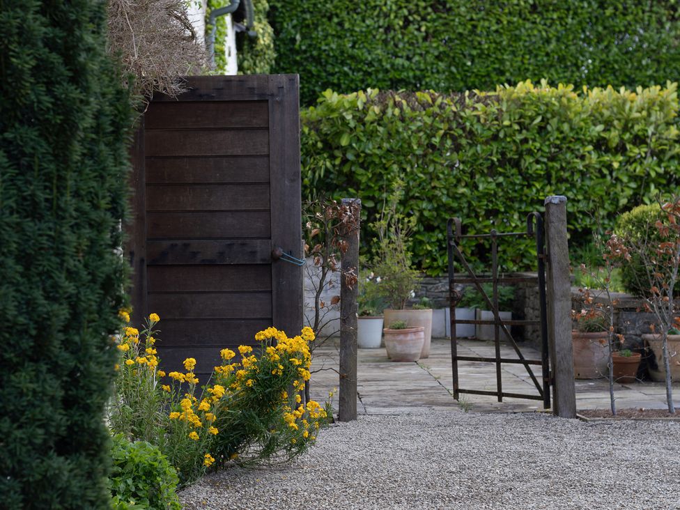 A garden with a wooden gate and flowers at North Cottage in Myddfai near Llandovery