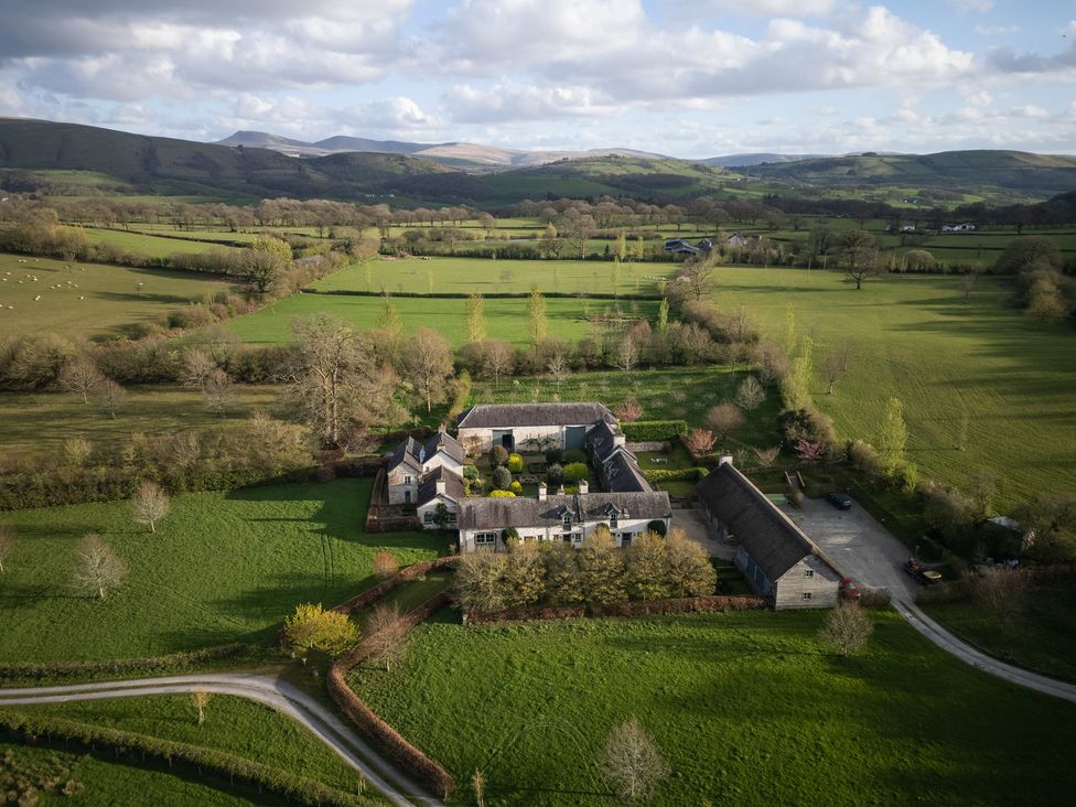 An outdoor view of a farm surrounded by fields and mountains at North Cottage in Myddfai near Llandovery