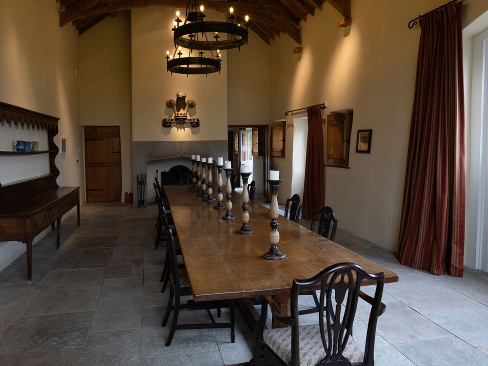 A dining room with a long table and chairs at North Cottage Myddfai near Llandovery