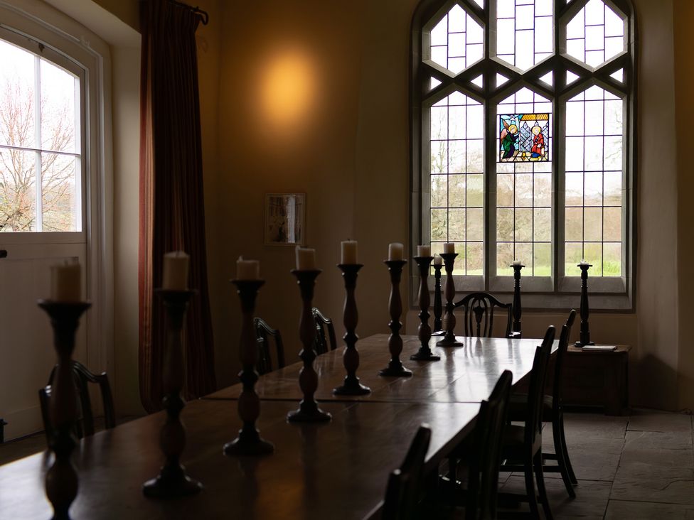 A dining room with a long table and candle holders at North Cottage in Myddfai near Llandovery