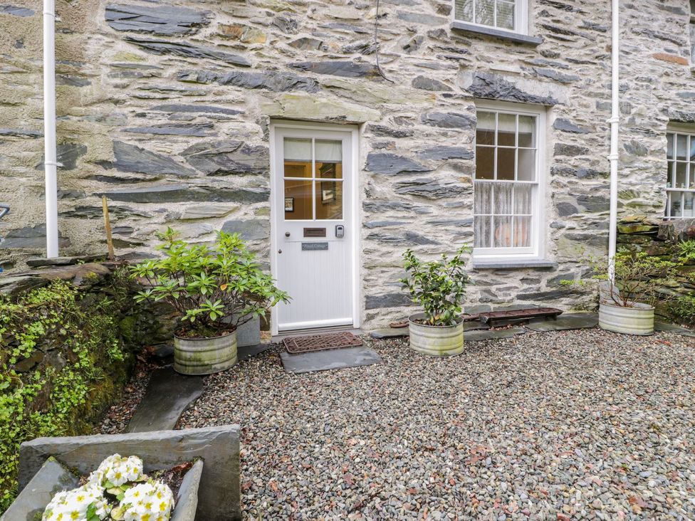 A entrance with a door and gravel area at Peniel Cottage in Caernarfon