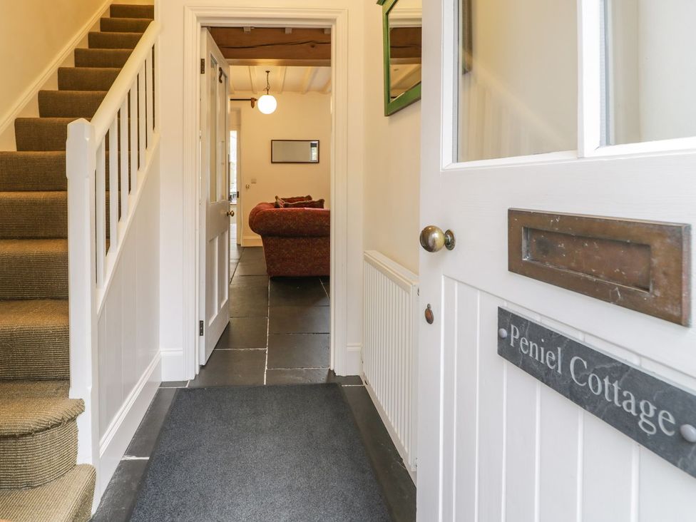 A hallway with stairs and a sofa at Peniel Cottage in Caernarfon