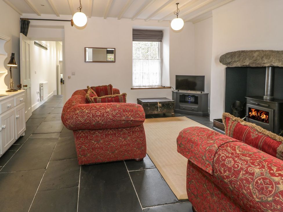 A living room with sofas and a fireplace at Peniel Cottage in Caernarfon