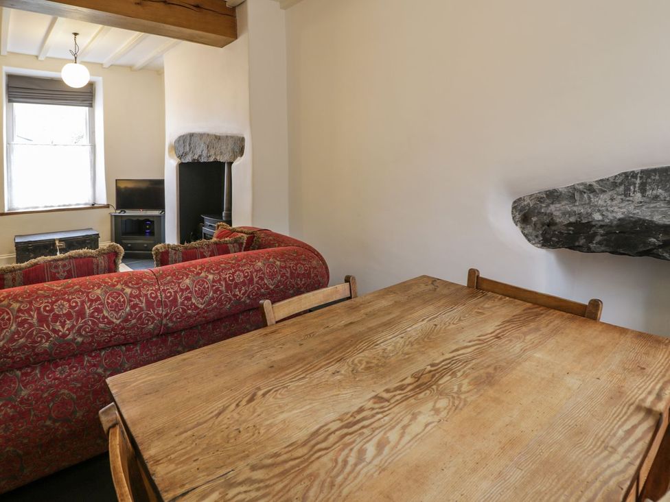 A living room with a sofa and table at Peniel Cottage in Caernarfon