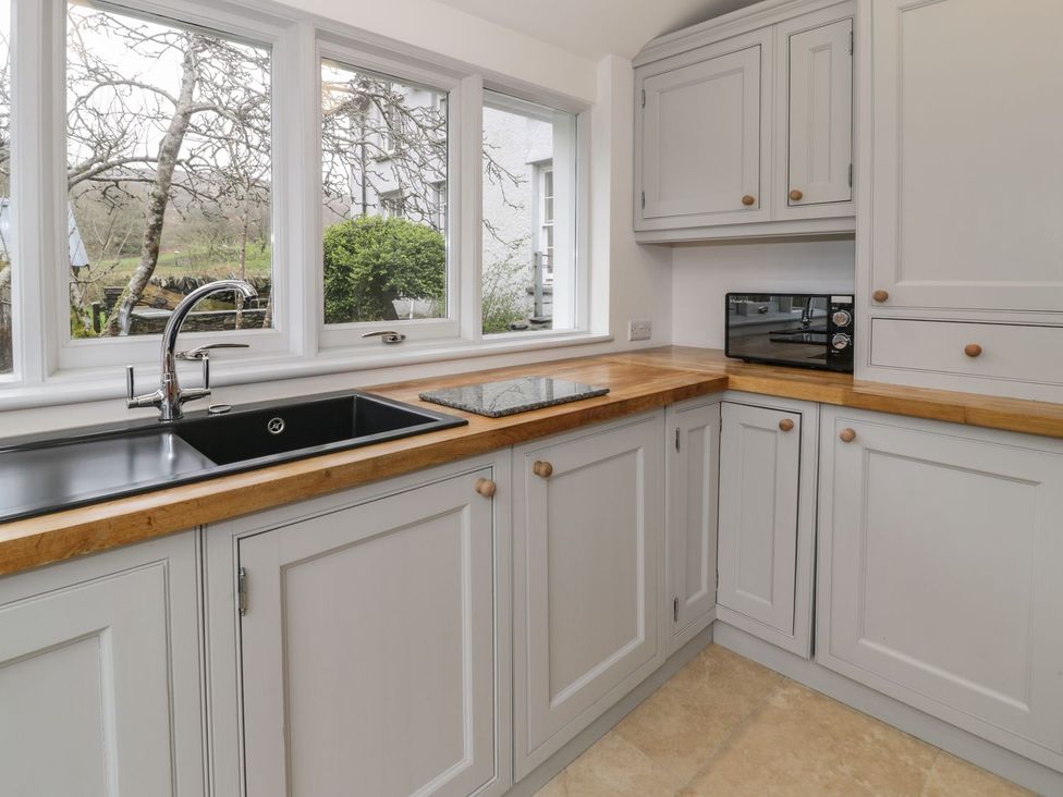 A kitchen with sink and microwave at Peniel Cottage Caernarfon