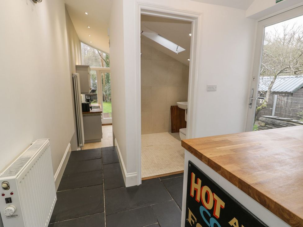 A kitchen with a fridge and a door at Peniel Cottage in Caernarfon