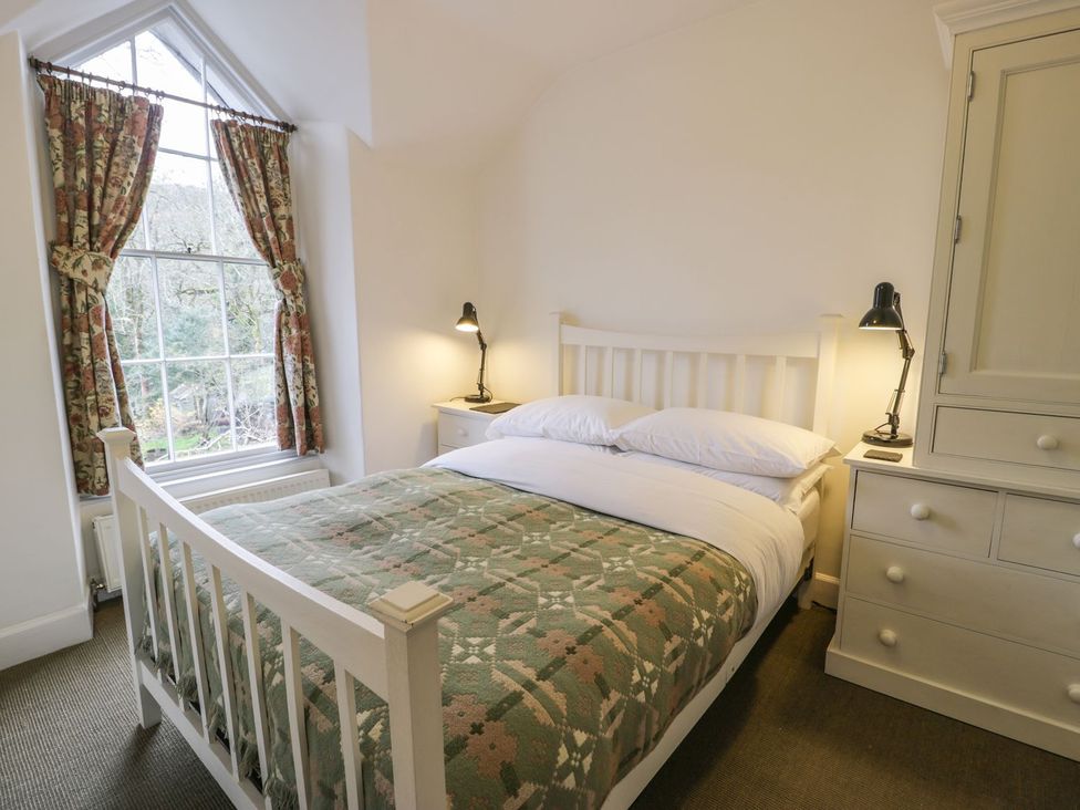 A bedroom with a bed and lamp at Peniel Cottage in Caernarfon