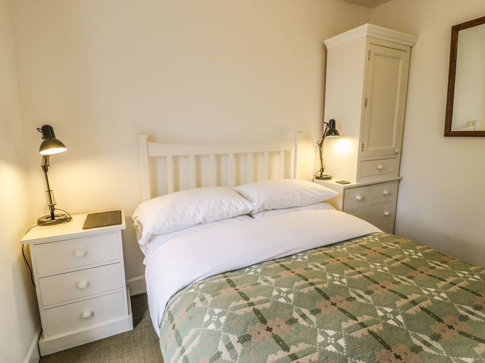 A bedroom with a bed and nightstands at Peniel Cottage in Caernarfon