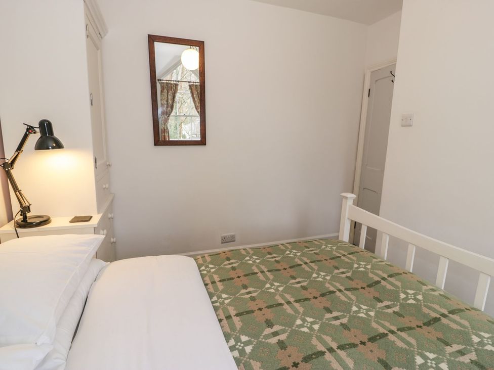 A bedroom with a bed and lamp at Peniel Cottage in Caernarfon