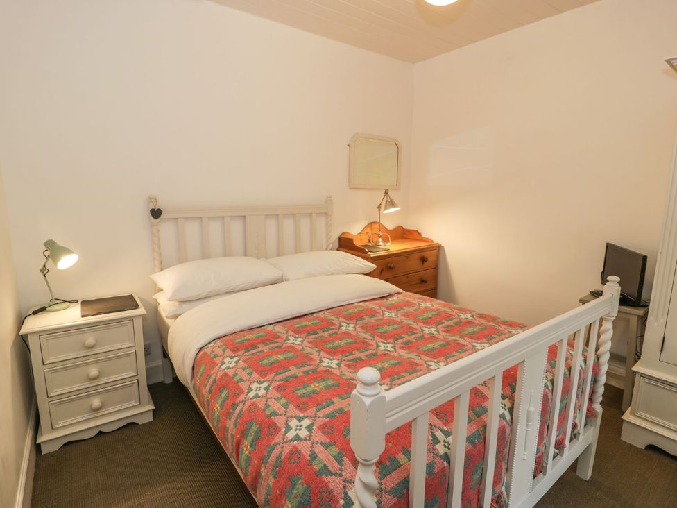 A bedroom with a bed and nightstand at Peniel Cottage in Caernarfon