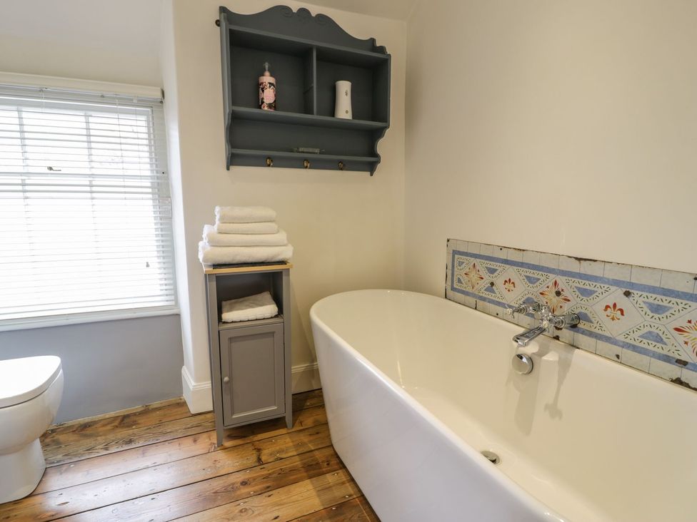 A bathroom with a bathtub and toilet at Peniel Cottage in Caernarfon