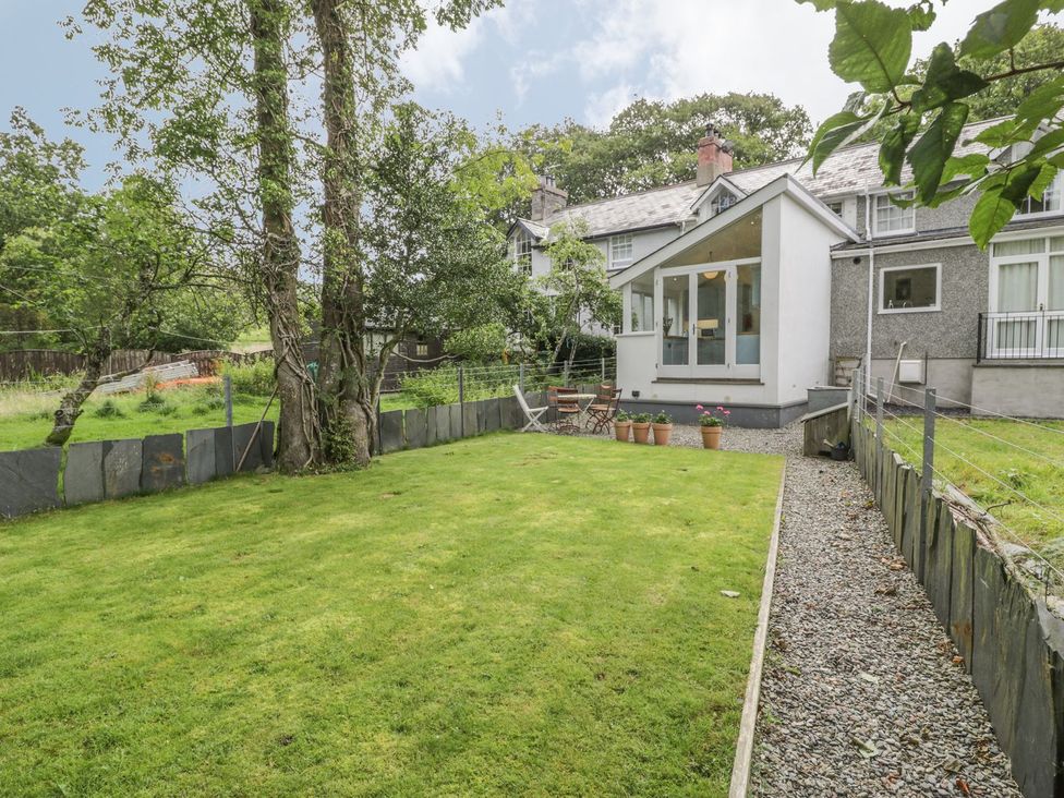 A garden with grass and trees at Peniel Cottage in Caernarfon