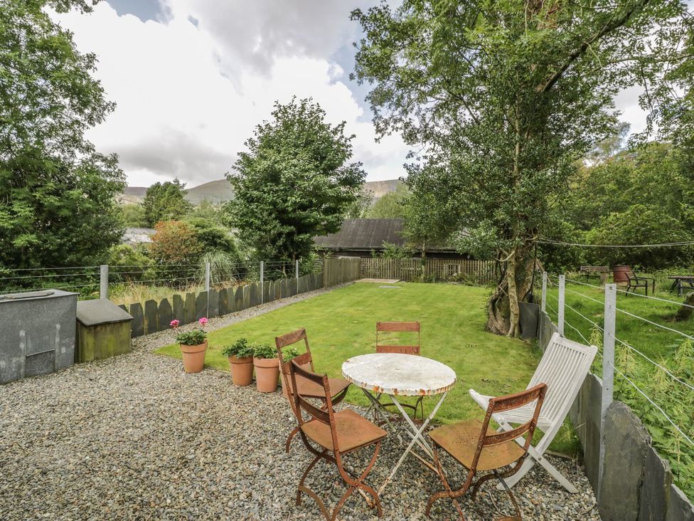 A garden with a table and chairs at Peniel Cottage in Caernarfon