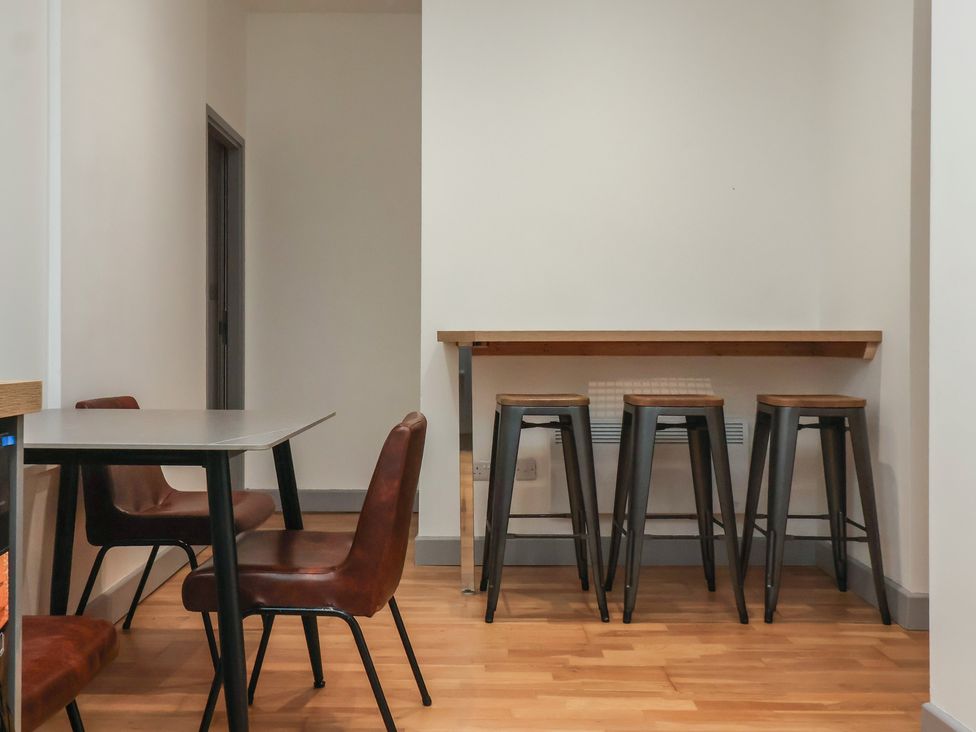 A kitchen with a table and chairs alongside bar stools at Apartment 10 York