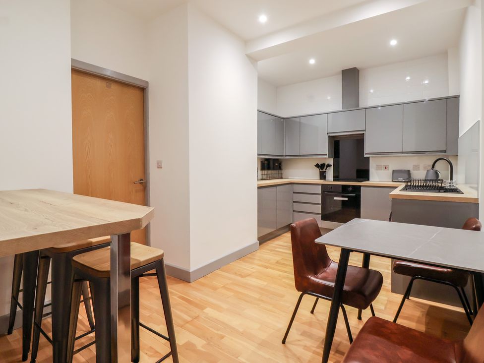 A kitchen with stools and a table at Apartment 10 in York