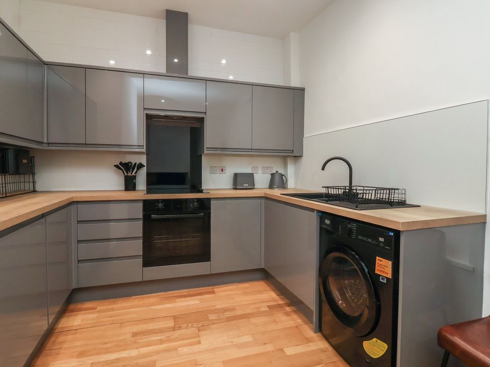 A kitchen with modern appliances and wooden countertop at Apartment 10 in York
