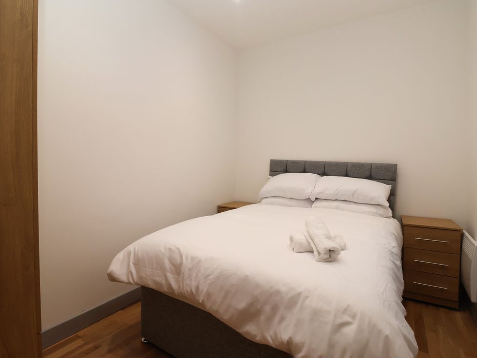 A bedroom with a bed and nightstands at Apartment 10 in York