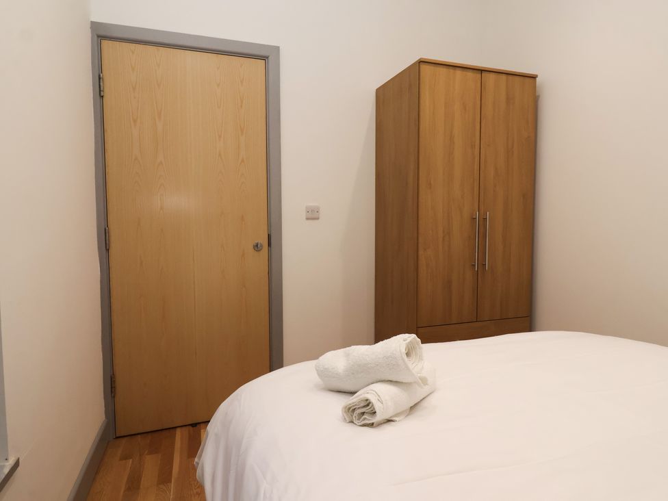 A bedroom with a wardrobe and towels on a bed at Apartment 10 in York