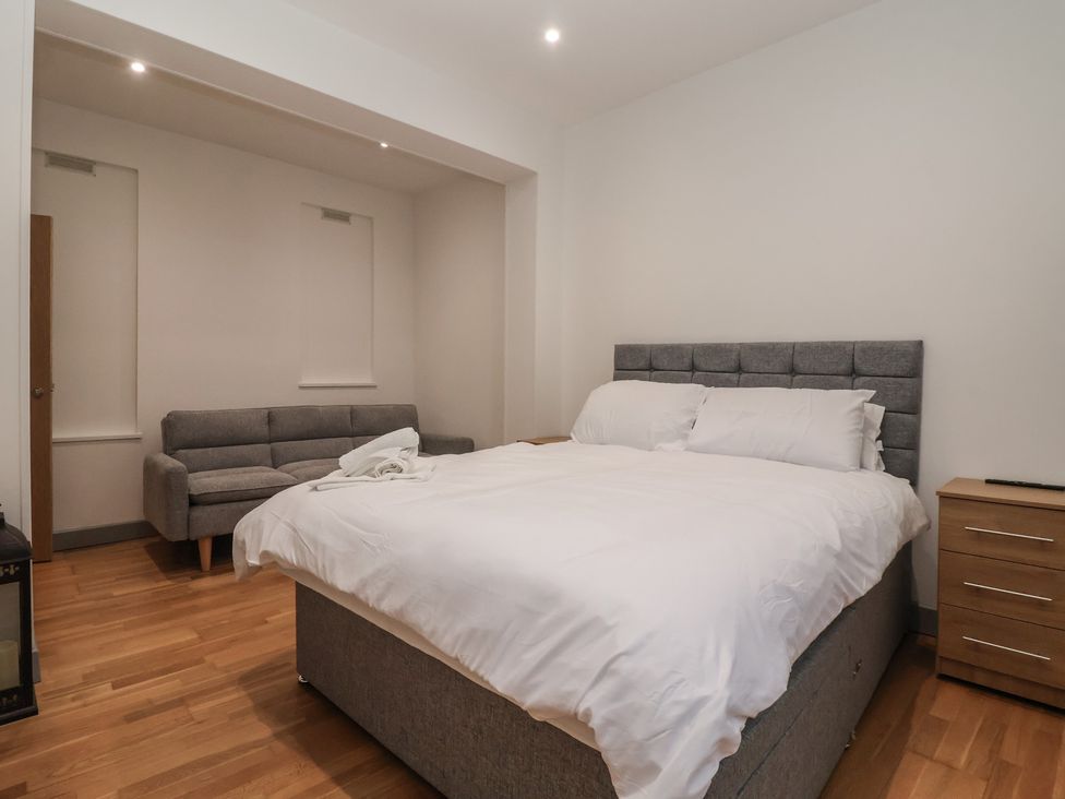 A bedroom with a bed and seating area at Apartment 10 in York
