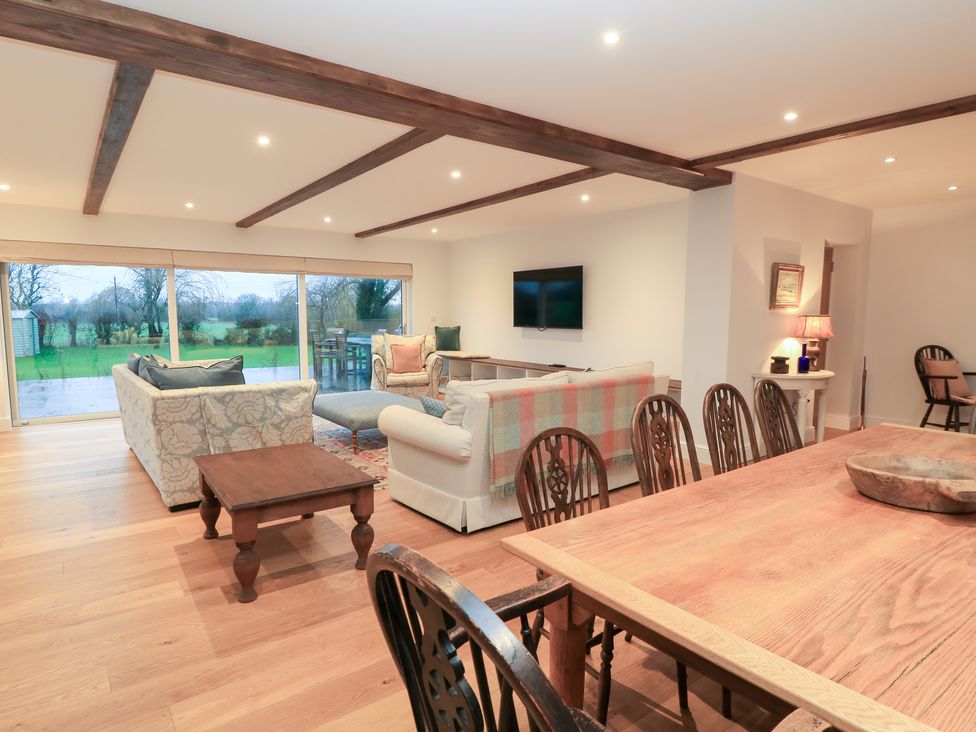 A living room with a sofa and dining area at Peewit Coach House in Moreton-in-Marsh