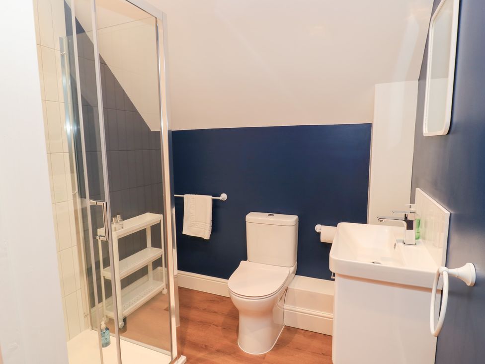 A bathroom with a shower, toilet, and sink at Peewit Coach House in Moreton-in-Marsh