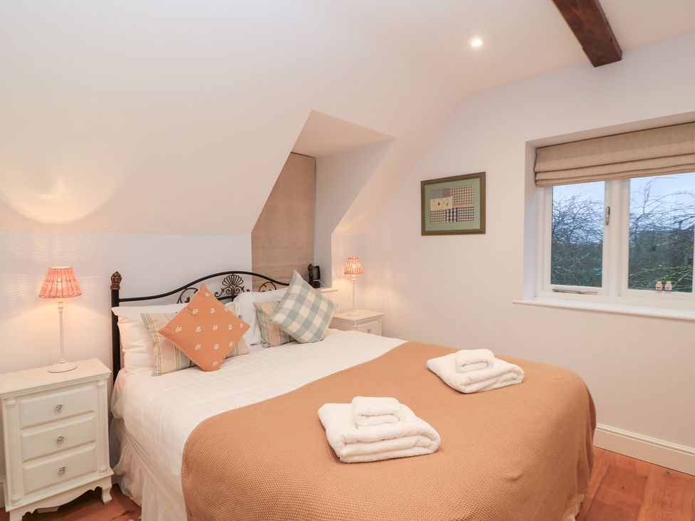 A bedroom with a bed and bedside tables at Peewit Coach House in Moreton-in-Marsh