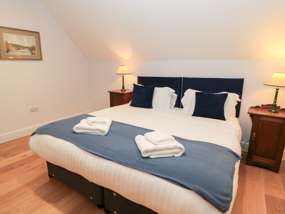 A bedroom with a bed and lamps at Peewit Coach House in Moreton-in-Marsh