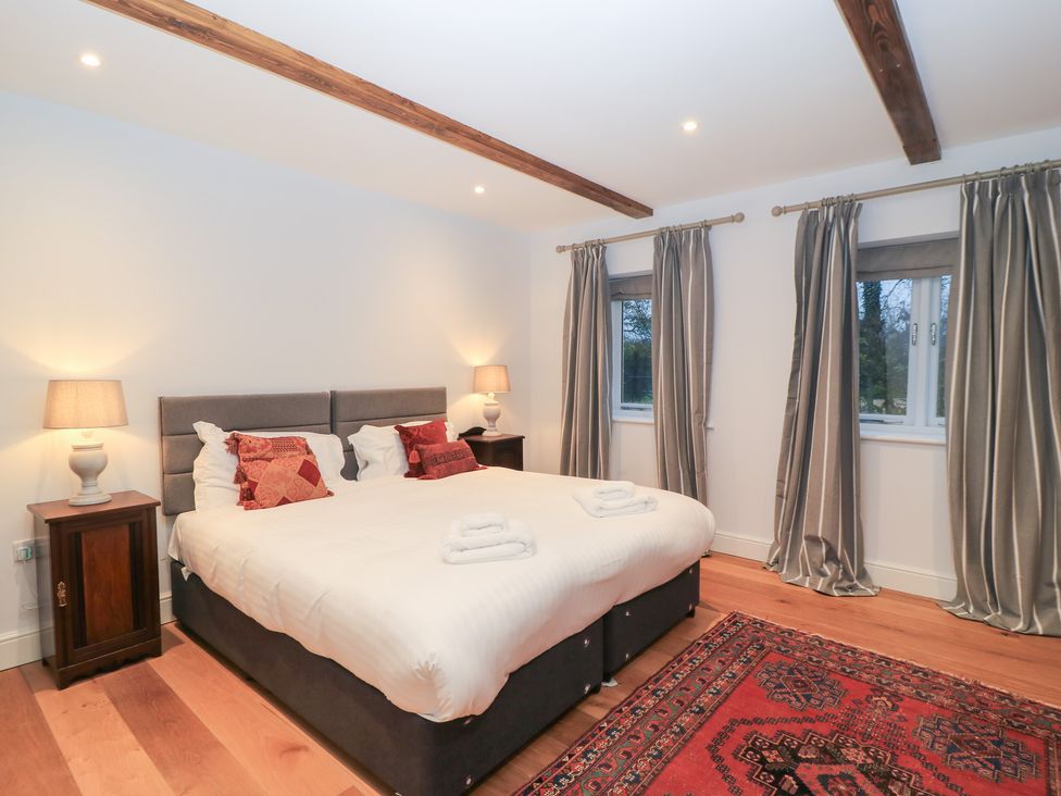 A bedroom with a bed and bedside tables at Peewit Coach House in Moreton-in-Marsh