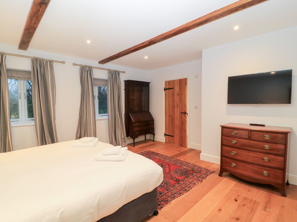 A bedroom with a bed and chest of drawers at Peewit Coach House in Moreton-in-Marsh