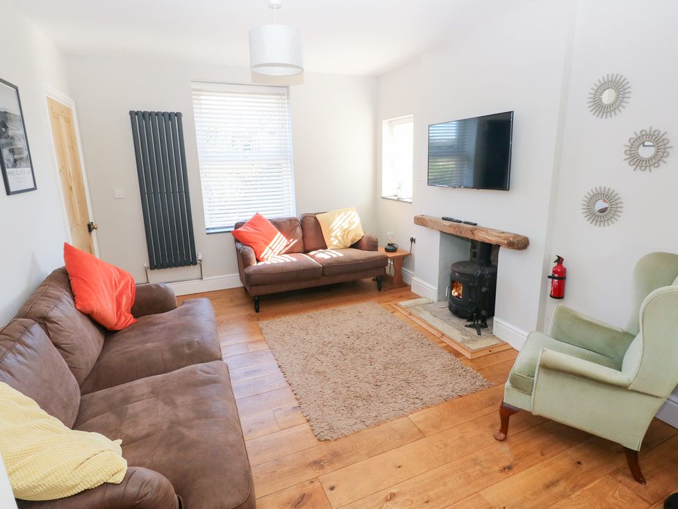 A living room with a sofa and television at Hawthorns Swansea