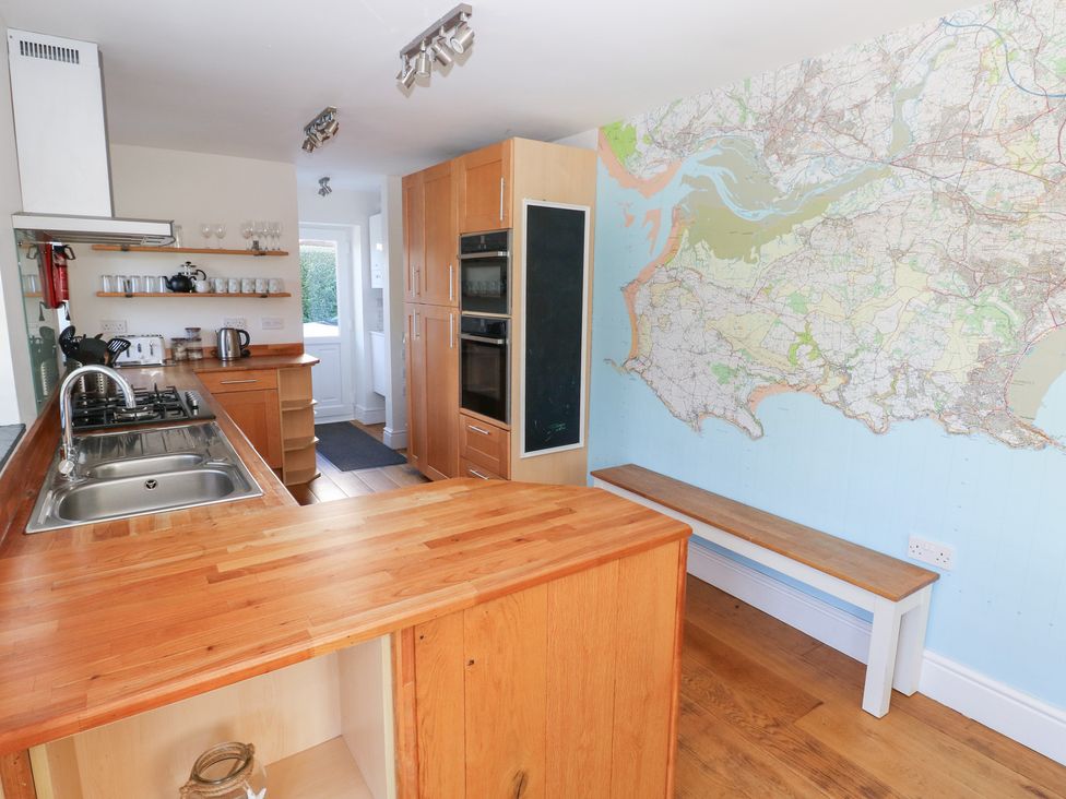 A kitchen with wood finish and a map on the wall at Hawthorns Swansea