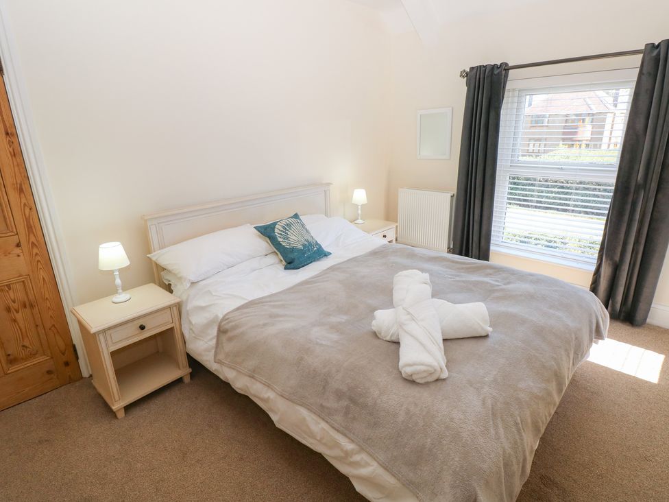 A bedroom with a double bed and nightstand at Hawthorns in Swansea