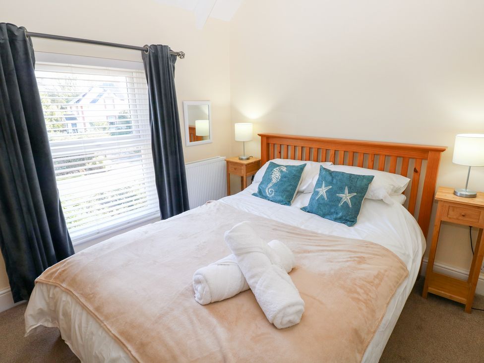A bedroom with a bed and bedside tables at Hawthorns in Swansea
