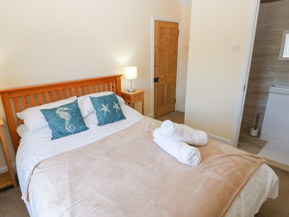 A bedroom with a bed and towels at Hawthorns in Swansea