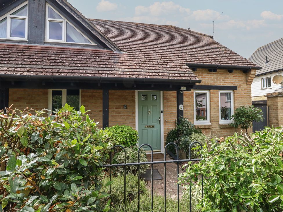 A house with a green door and windows at June Cottage in Wool
