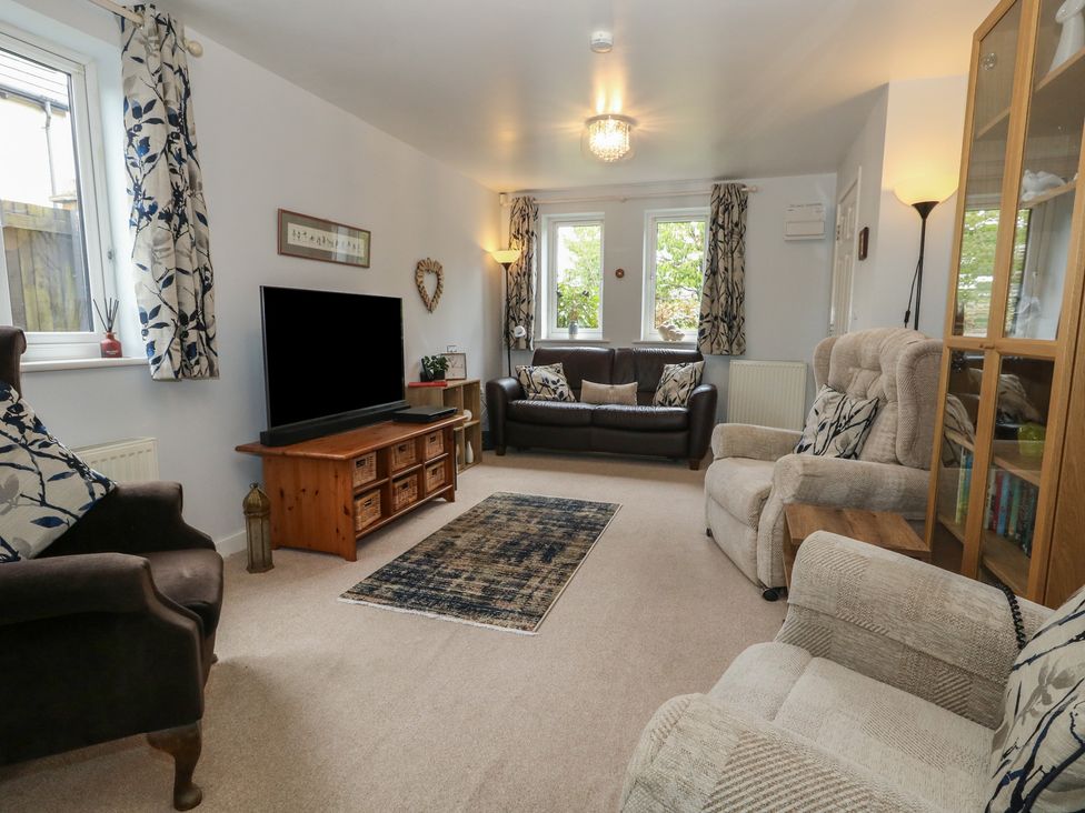 A living room with sofas and a television at June Cottage in Wool
