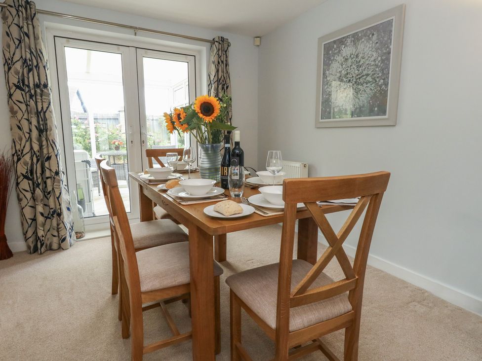 A dining room with a table set for a meal at June Cottage in Wool