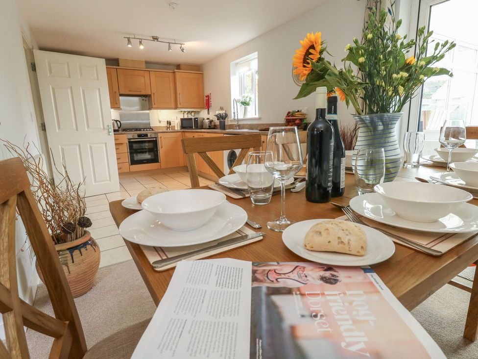 A kitchen with a dining table set at June Cottage in Wool
