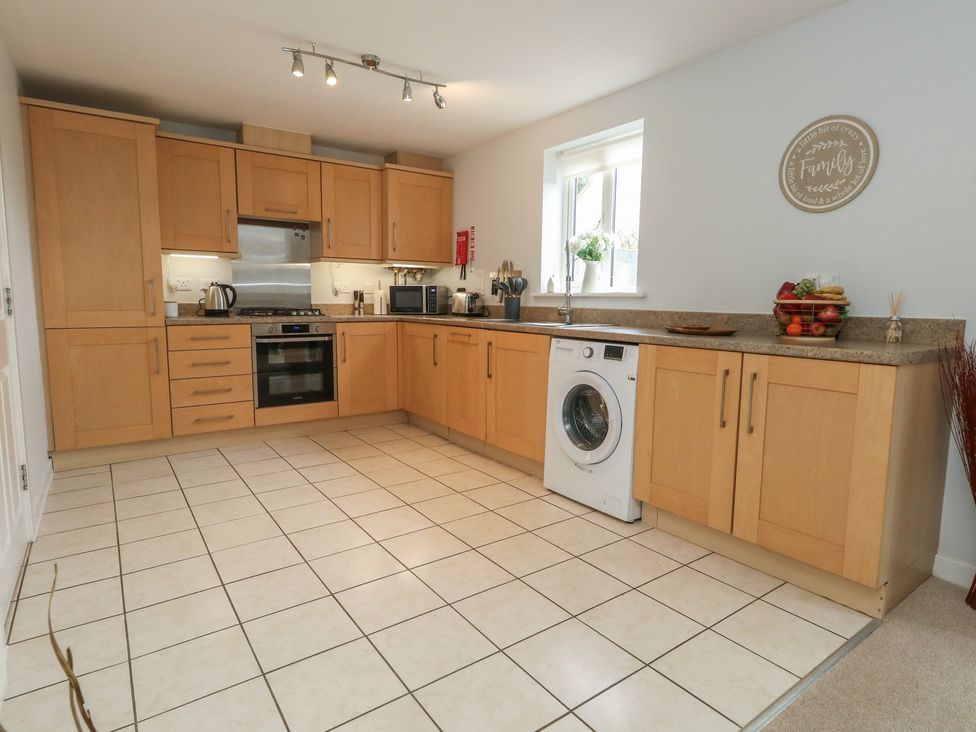 A kitchen with wooden cabinets and appliances at June Cottage in Wool