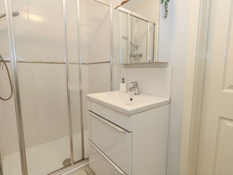 A bathroom with a shower and a sink at June Cottage in Wool
