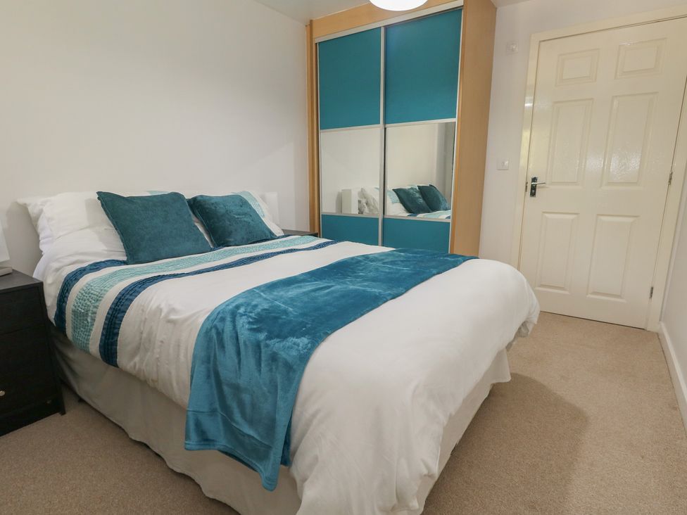 A bedroom with a bed and wardrobe at June Cottage in Wool