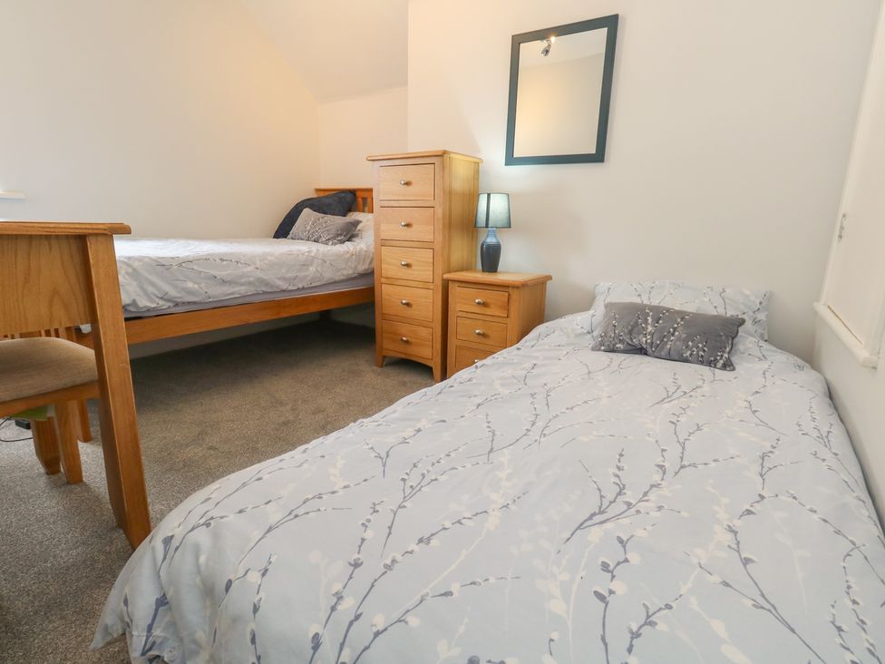 A bedroom with two beds and a dresser at June Cottage in Wool