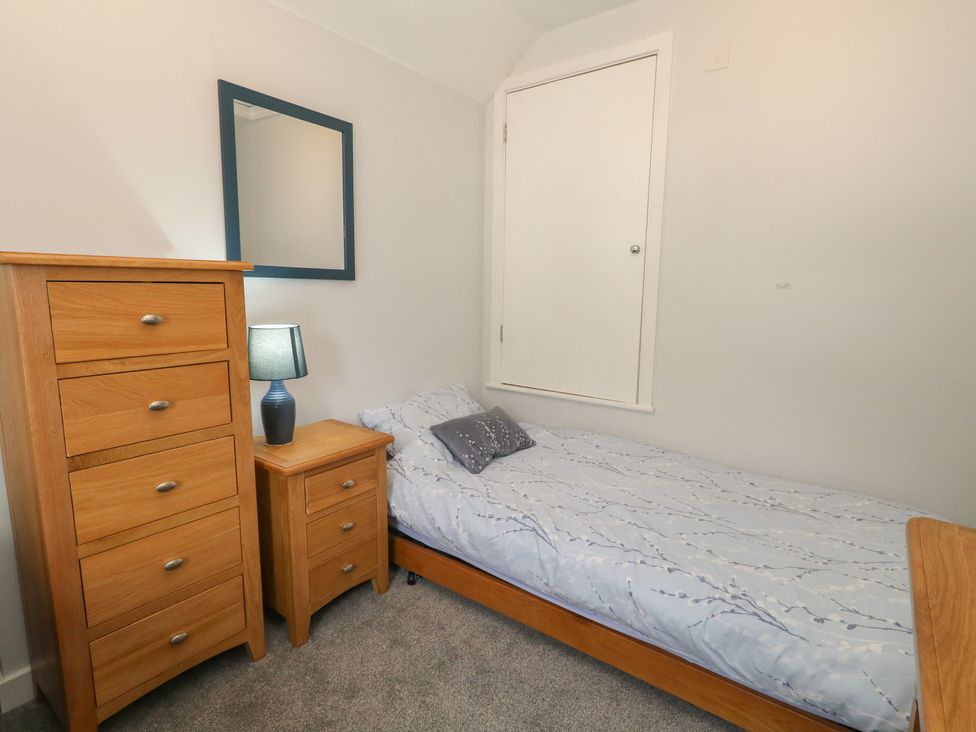 A bedroom with a bed and furniture at June Cottage in Wool
