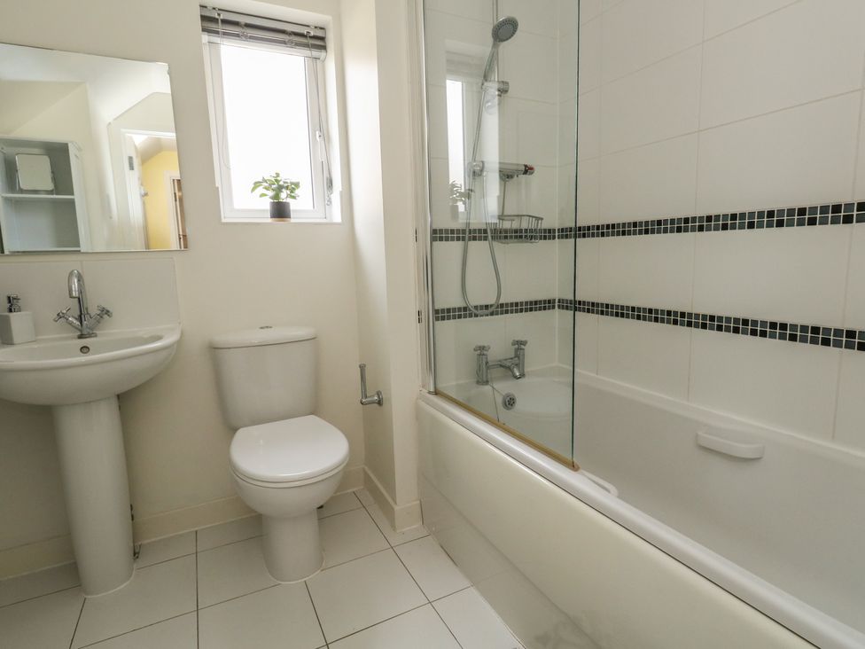 A bathroom with a bathtub, shower, toilet, and sink at June Cottage in Wool