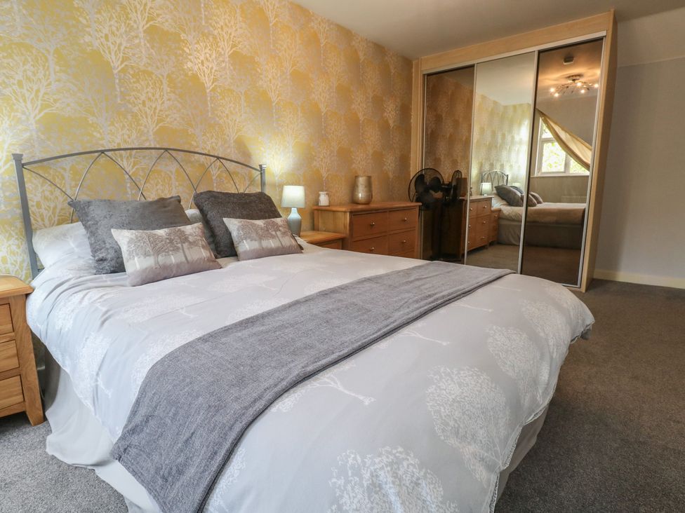 A bedroom with a bed and nightstand at June Cottage in Wool
