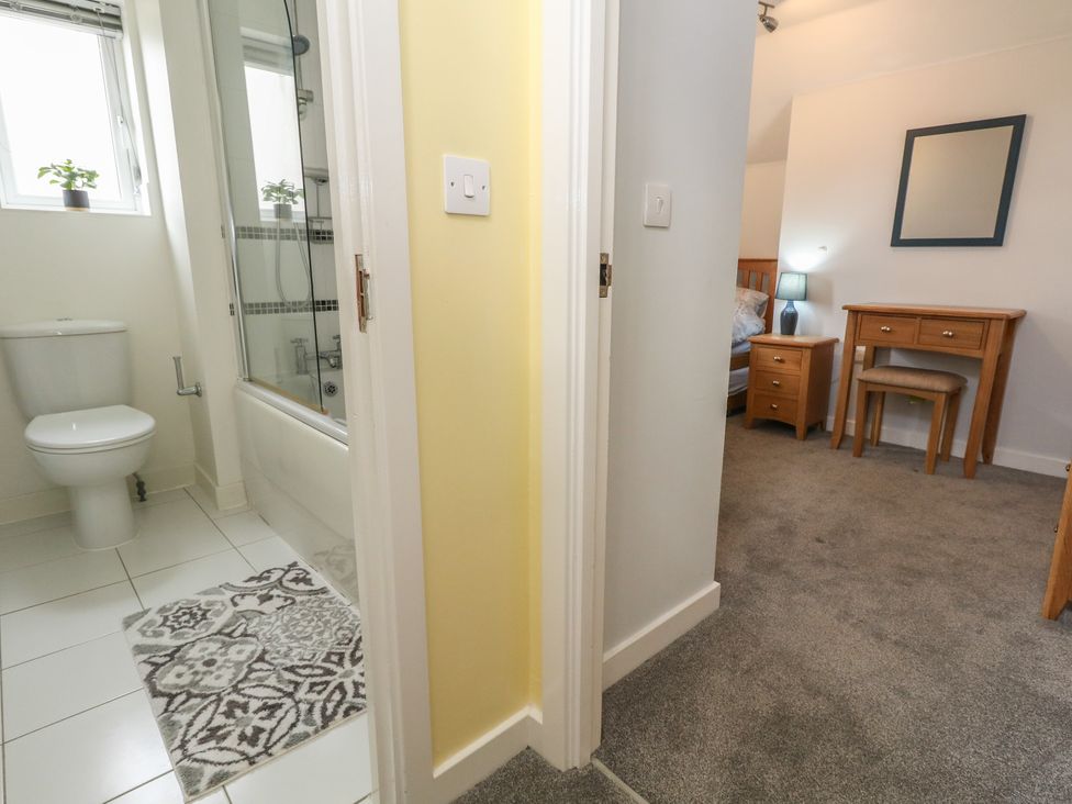A bathroom with a toilet and bathtub at June Cottage in Wool