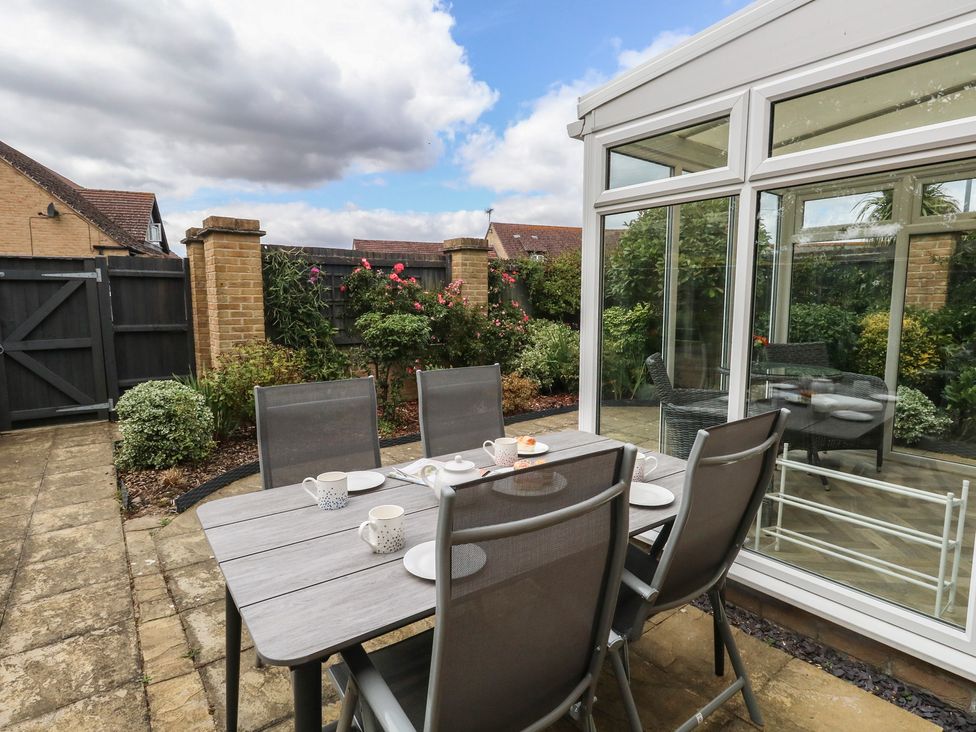 A garden with a dining set and tea cups at June Cottage in Wool