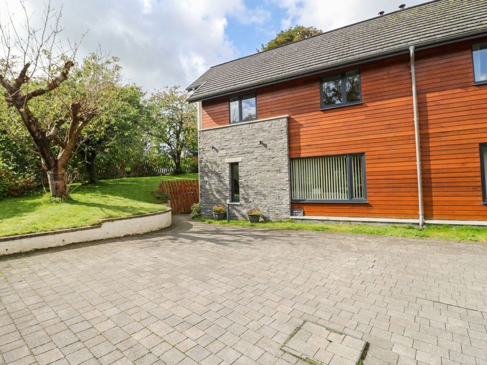 An exterior view of a house with stone wall and windows at 1 Balnakeil in Dunbeg